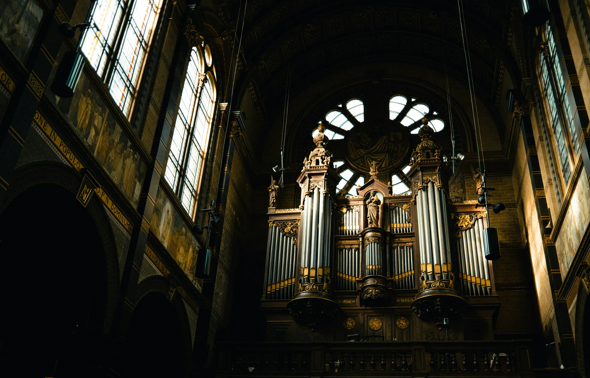 Stort pipeorgel i et kirkerom med glassmalerier